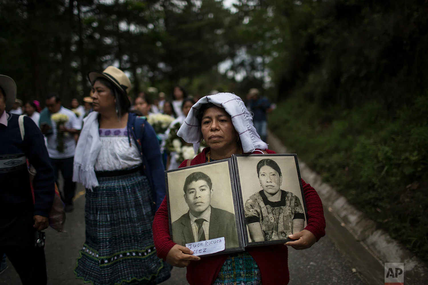 Marivel Yolanda Rucuch carries portraits of her father Juan Rucuch and aunt Virgilia Quina who were disappeared in the 1980's, allegedly by the army. June 21, 2018 (AP Photo/Rodrigo Abd)