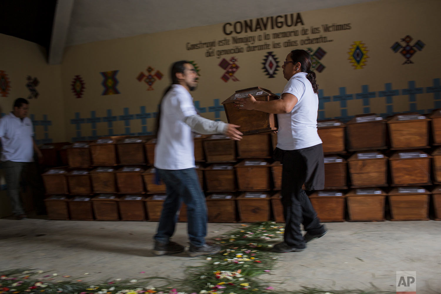  In this June 21, 2018 photo, forensic anthropologists organize the remains of 172 unidentified people who were exhumed from what was once a military camp, before properly burying them at the same spot where they were discovered in San Juan Comalapa,