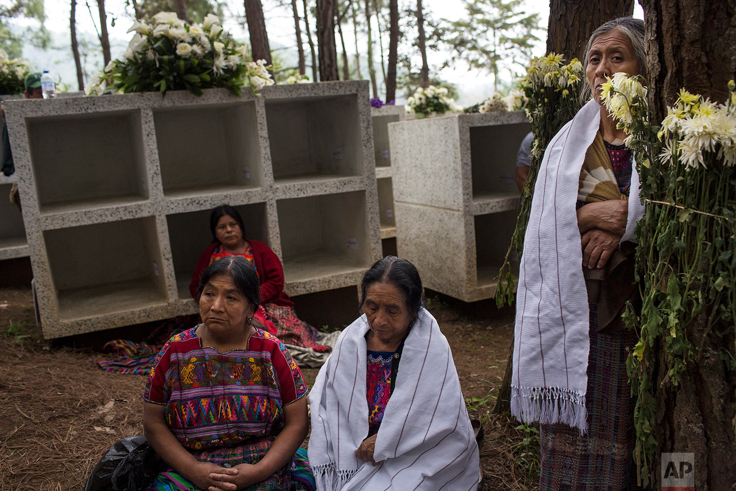  In this June 21, 2018 photo, women attend the funeral ceremony for 172 unidentified people who were discovered buried at what was once a military camp, during their proper burial ceremony at the same spot where they were found in San Juan Comalapa, 