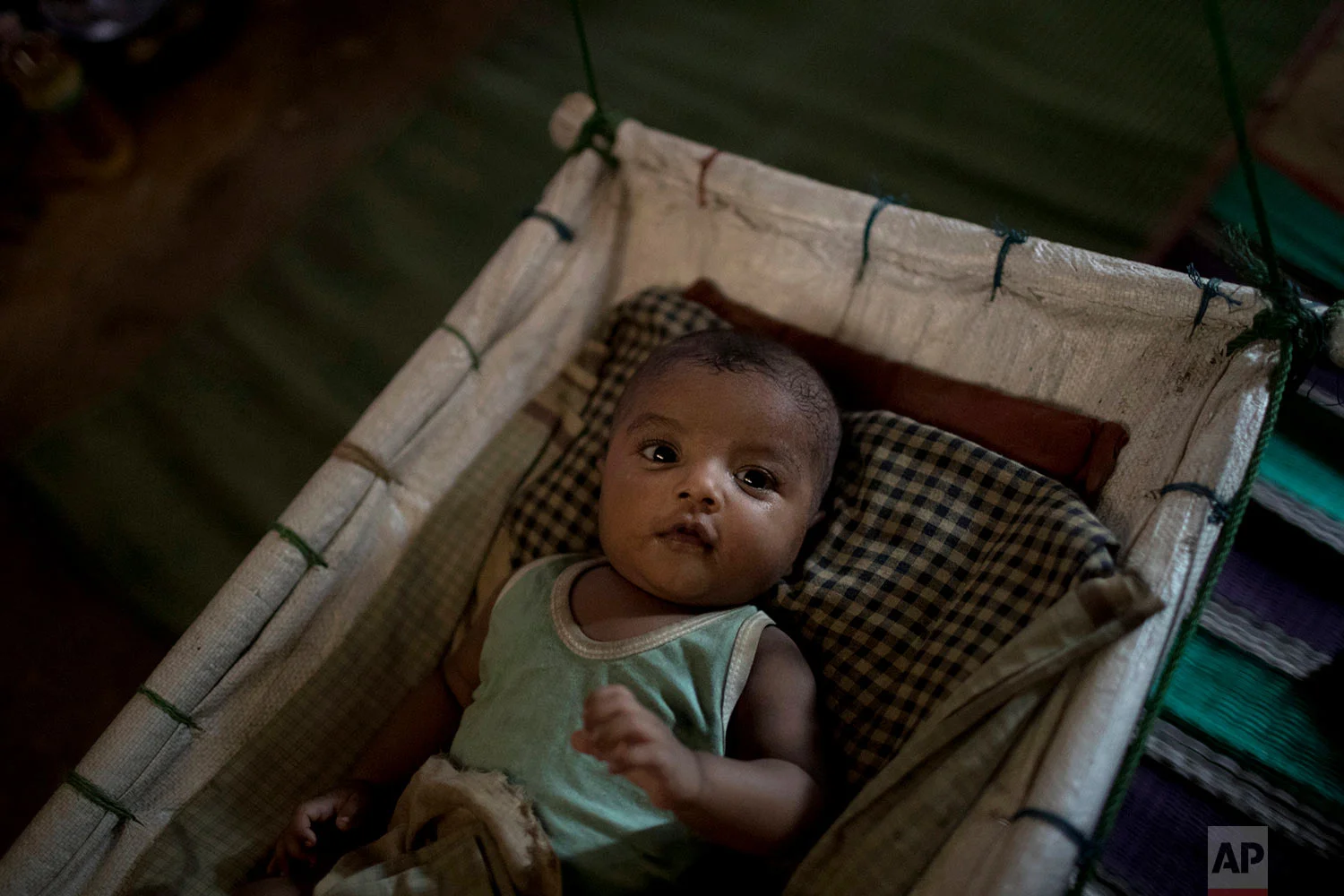 "M" sits in her shelter, uninterested in her baby boy who had awoken from his sleep, in Kutupalong refugee camp in Bangladesh, June 26, 2018. (AP Photo/Wong Maye-E)