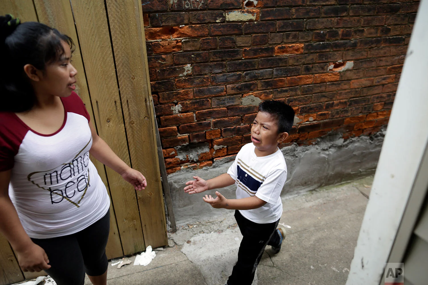 Carmelinda Perez tries to sooth her crying son, Franco, after he ran out of the house looking for his father in Florence, Ky. (AP Photo/Gregory Bull)