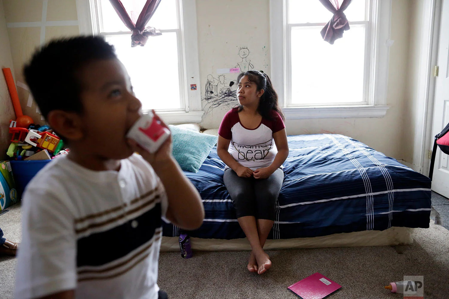 Franco Perez walks near his mother, Carmelinda, in their apartment in Covington, Ky. (AP Photo/Gregory Bull)