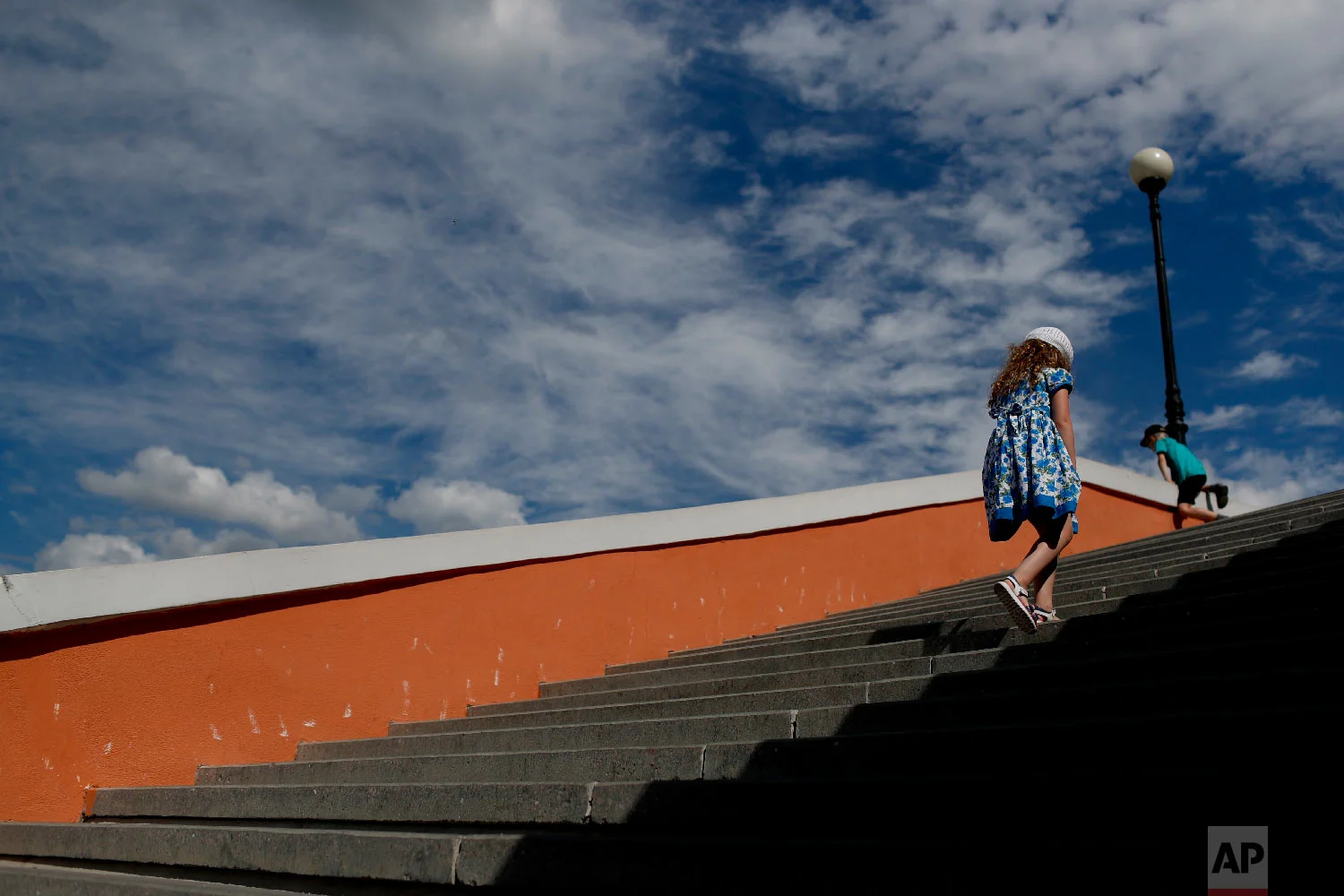 A girl walks up the stairs during the 2018 soccer World Cup in Nizhny Novgorod, Russia on Wednesday, July 4, 2018. (AP Photo/Natacha Pisarenko)