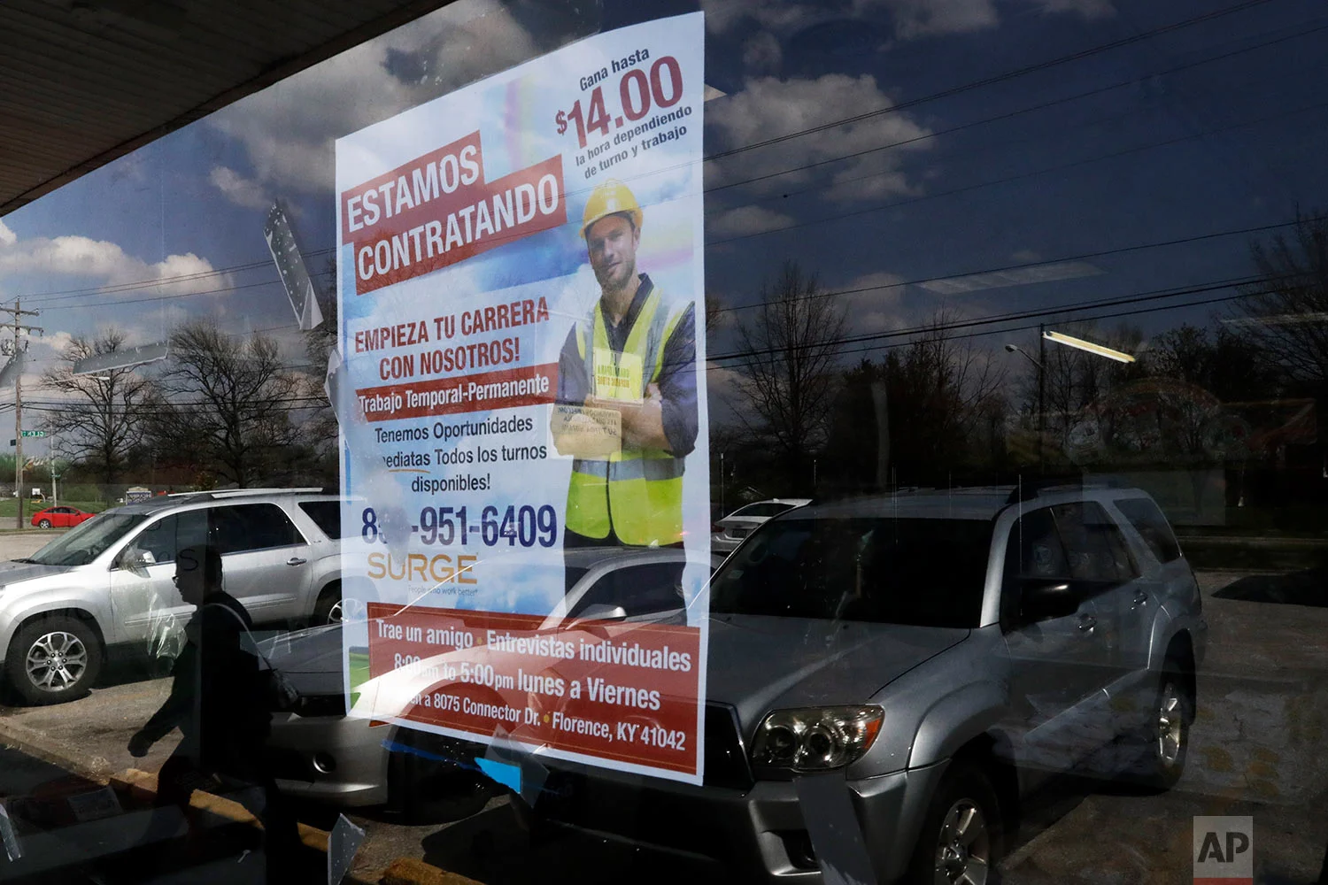 A poster announcing available jobs hangs in the window of the store La Guadalupana in Florence, Ky. (AP Photo/Gregory Bull)