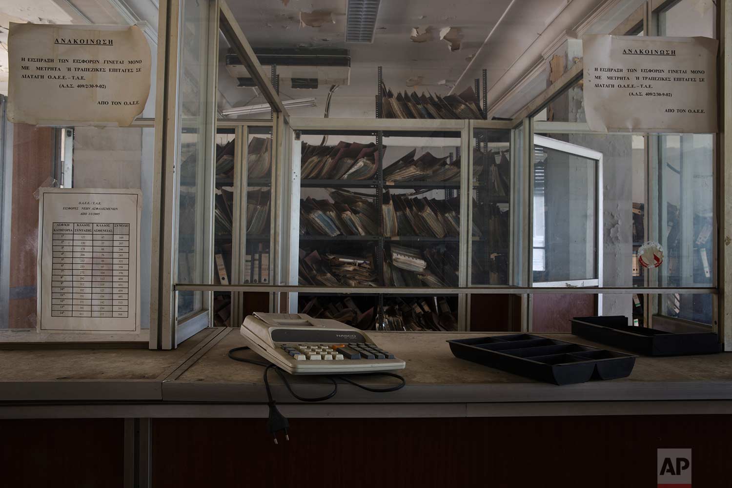 A calculator on a booth in front of shelves of paper files in a 2,600-square meter listed building from 1955, formerly used by a commerce fund company. (AP Photo/Petros Giannakouris)