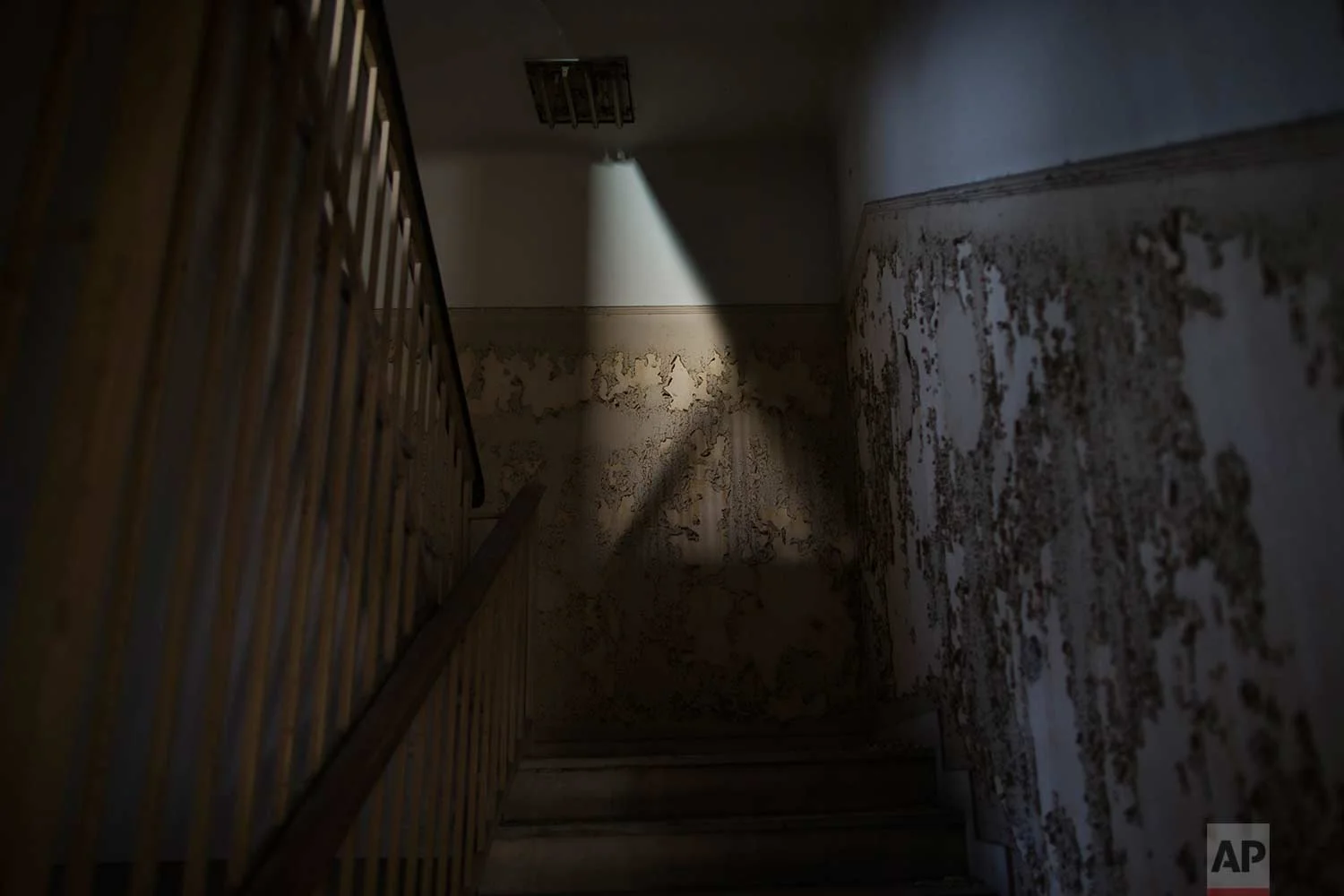 Peeling walls by a staircase inside a 7-story block off central Athens' gritty Omonia Square, that has been untenanted since a now-defunct farm cooperative fund left years ago. (AP Photo/Petros Giannakouris)