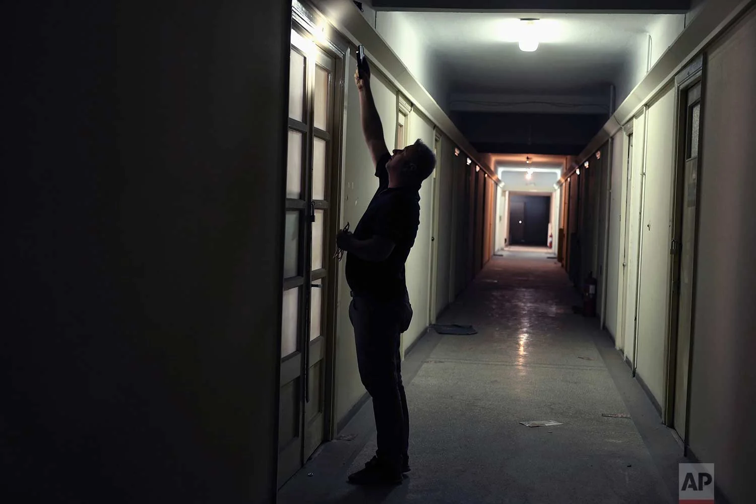 A pension fund employee in an office doorway in one of Athens' few substantial late 19th century buildings to survive brutal postwar development. (AP Photo/Petros Giannakouris)