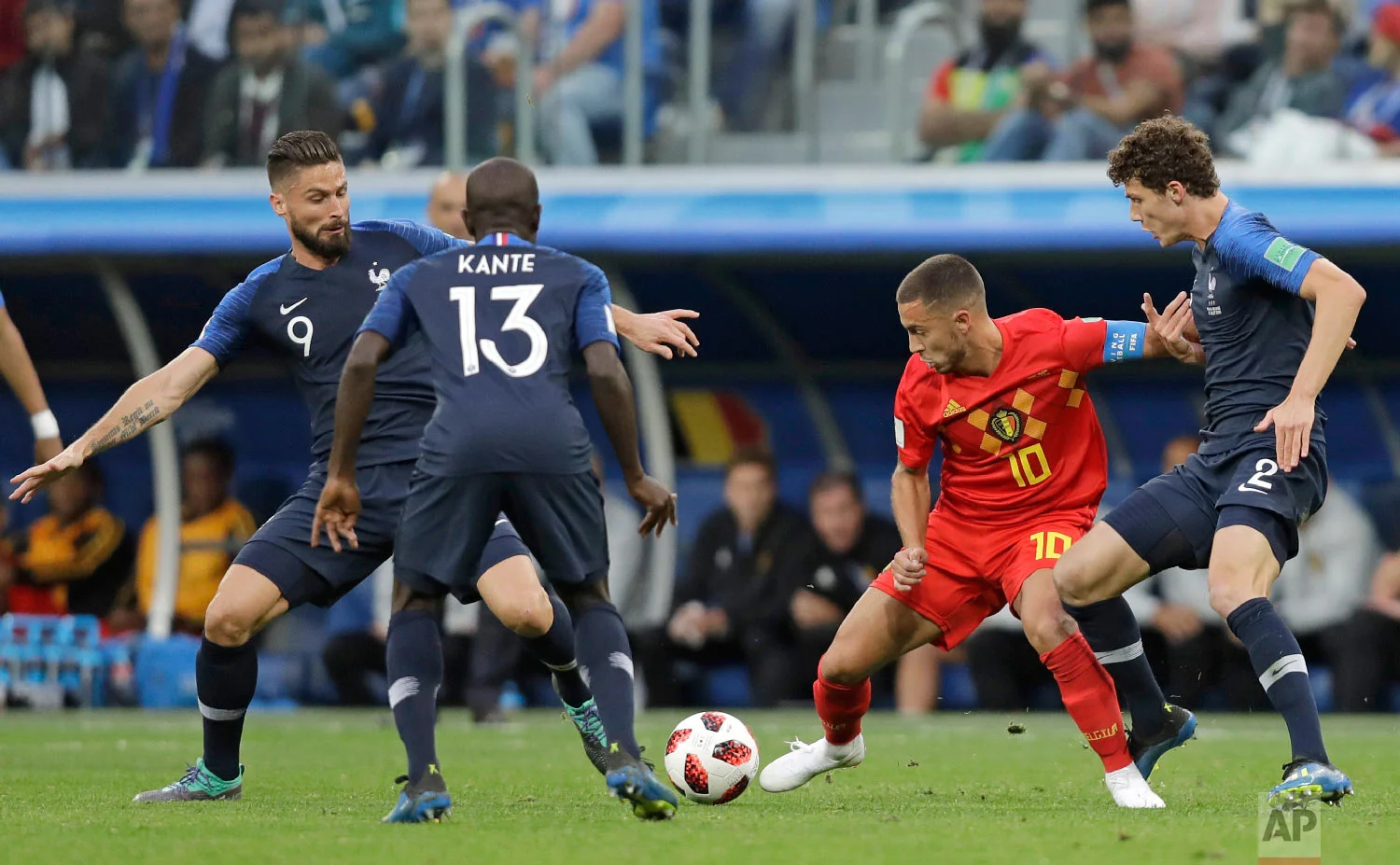 Belgium's Eden Hazard, second right is challenged for the ball by France's Benjamin Pavard, right and France's Olivier Giroud left, during the semifinal match between France and Belgium at the 2018 soccer World Cup in the St. Petersburg Stadium in, St. Petersburg, Russia, Tuesday, July 10, 2018. (AP Photo/Natacha Pisarenko)