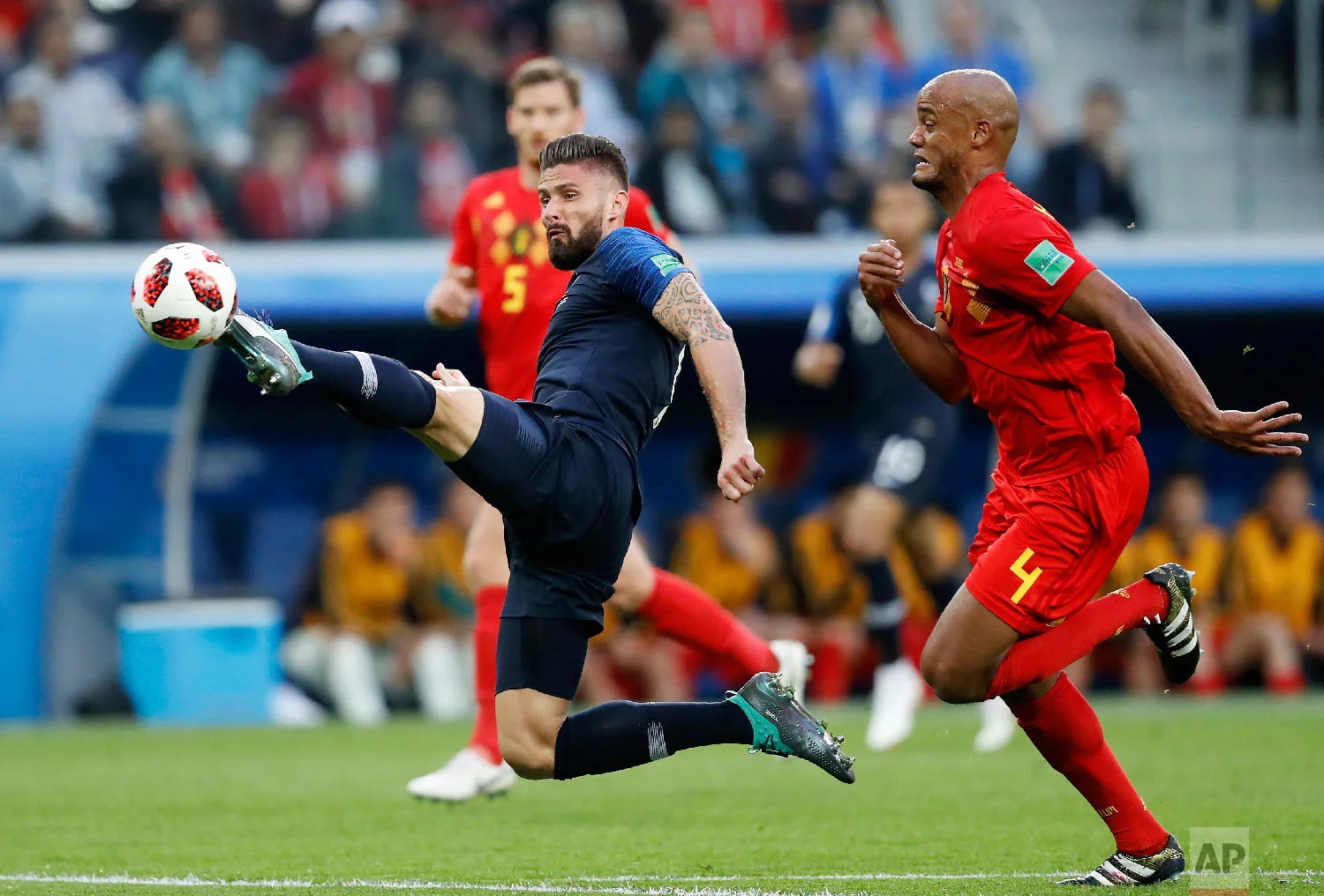 France's Olivier Giroud, left, tries to control the ball with Belgium's Vincent Kompany during the semifinal match between France and Belgium at the 2018 soccer World Cup in the St. Petersburg Stadium, in St. Petersburg, Russia, Tuesday, July 10, 2018. (AP Photo/David Vincent)