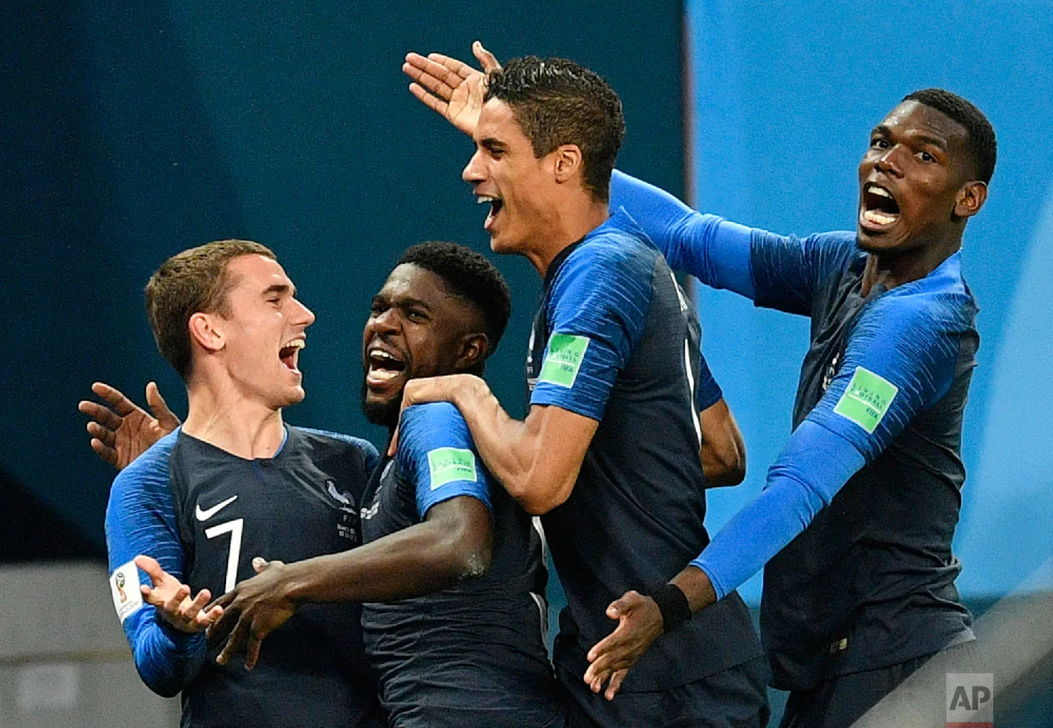 France's Samuel Umtiti, second from left, is congratulated by his teammates France's Antoine Griezmann, Raphael Varane and Paul Pogba, from left, after scoring the opening goal during the semifinal match between France and Belgium at the 2018 soccer World Cup in the St. Petersburg Stadium in St. Petersburg, Russia, Tuesday, July 10, 2018. (AP Photo/Martin Meissner)