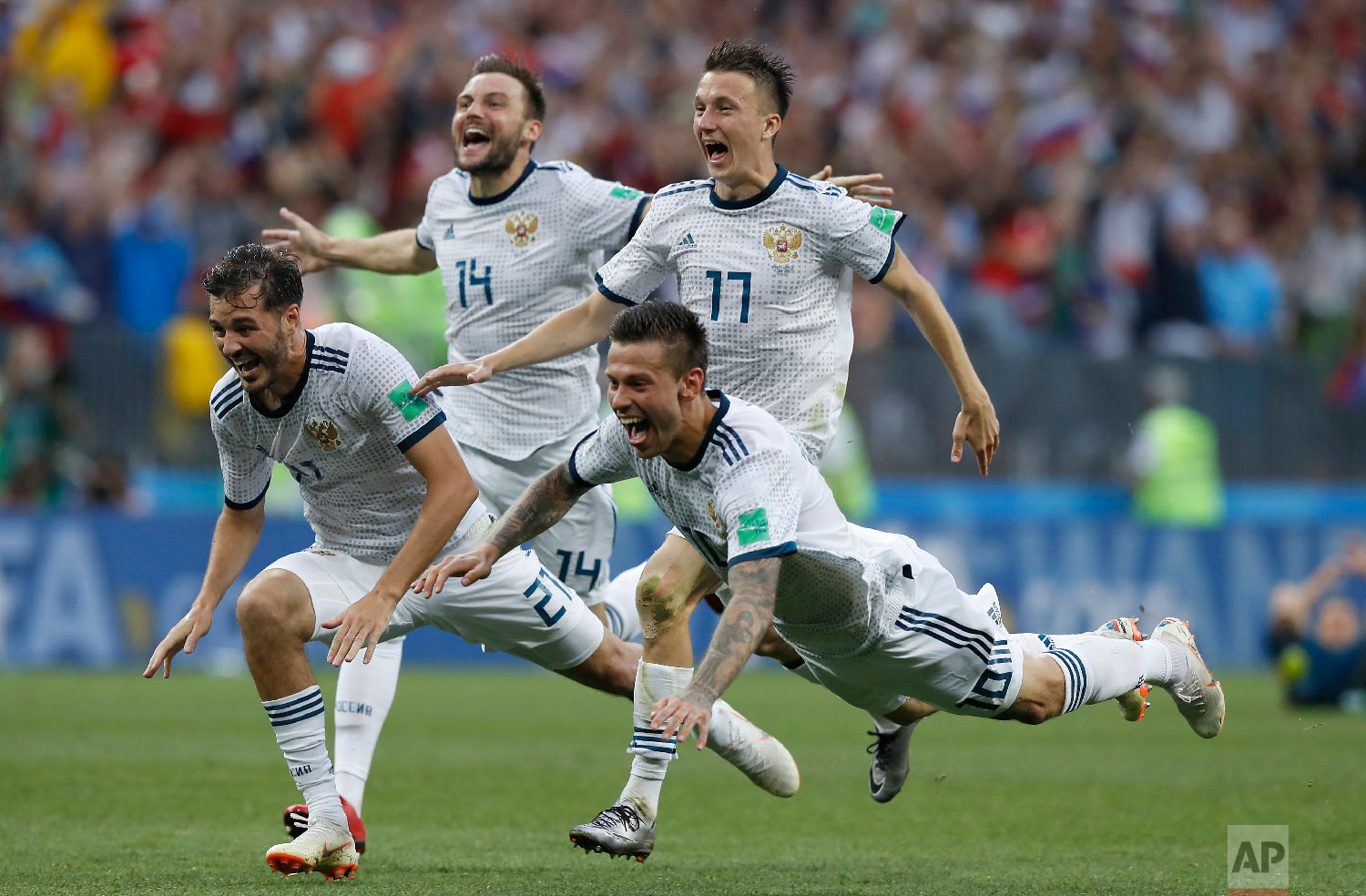  Russia's Fyodor Smolov, right, dives as he celebrates with teammates after Russia defeated Spain in a penalty shoot out during the round of 16 match between Spain and Russia at the 2018 soccer World Cup at the Luzhniki Stadium in Moscow, Russia on J