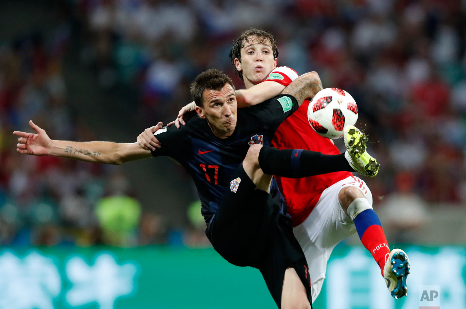  Croatia's Mario Mandzukic, left, challenges for the ball with Russia's Mario Fernandes during the quarterfinal match between Russia and Croatia at the 2018 soccer World Cup in the Fisht Stadium, in Sochi, Russia on July 7, 2018. (AP Photo/Rebecca Bl