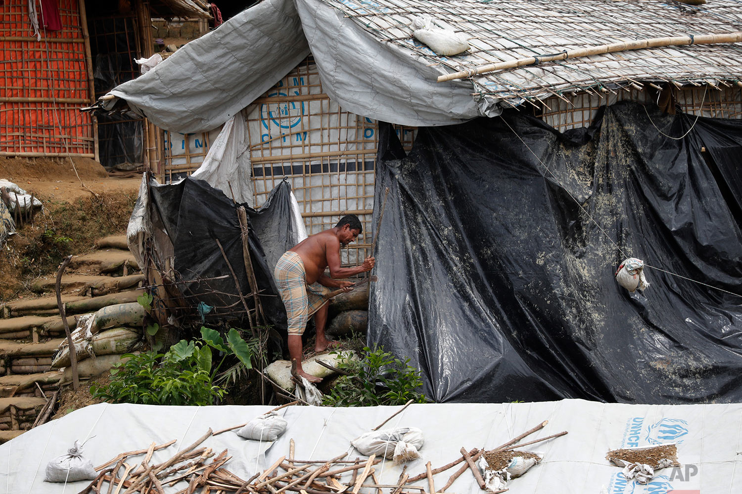  In this Wednesday, June 27, 2018, photo, a man covers his shelter with waterproof tarp as he prepares for the monsoon season in Chakmarkul refugee camp, Bangladesh. (AP Photo/Wong Maye-E) 