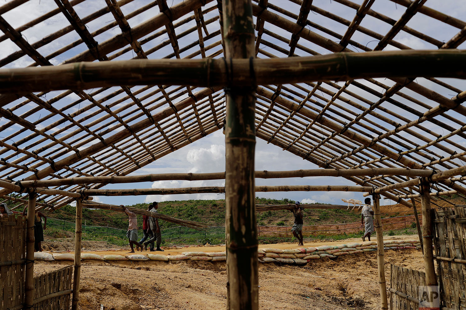  In this Thursday, June 28, 2018, photo, Rohingya refugees build new huts in an extended area of Kutupalong refugee camp in Bangladesh where some refugees living in areas considered at risk of landslides and flooding were relocated to.  (AP Photo/Won