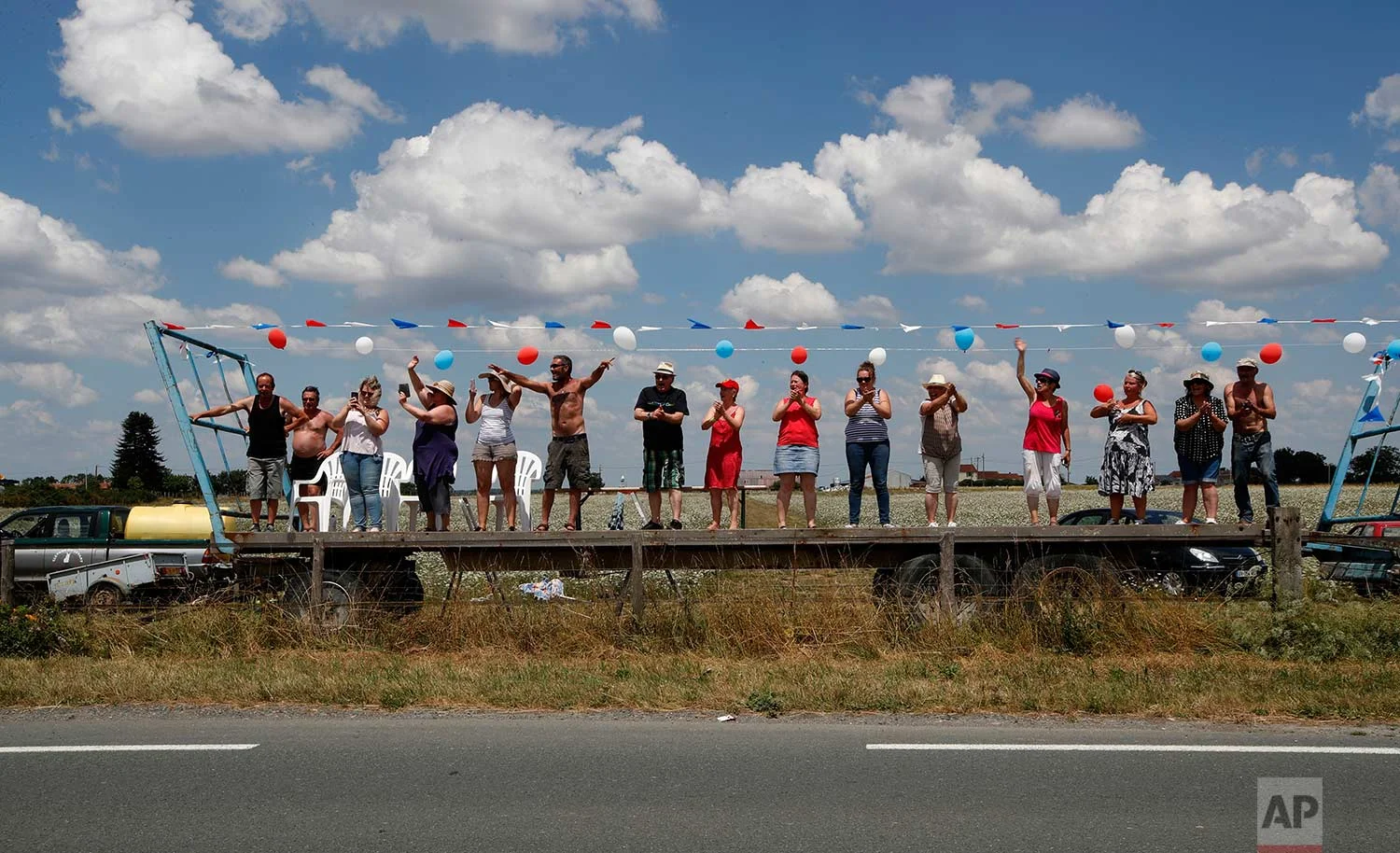 Spectators wait for the pack to pass during the first stage of the Tour de France cycling race over 201 kilometers (124.9 miles) with start in Noirmoutier-en-L'Ile and finish in Fontenay Le-Comte, France, Saturday, July 7, 2018. (AP Photo/Christophe Ena)