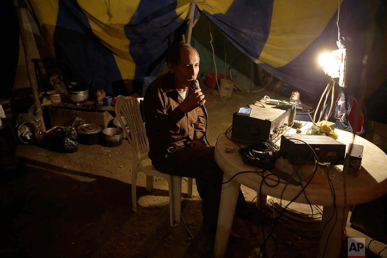  Circus owner and clown Jose Alvarez talks into a loud speaker system to announce the soon-to-start opening act, from the circus tent set up in the shantytown of Puente Piedra on the outskirts of Lima, Peru, July 8, 2018. (AP Photo/Martin Mejia) 