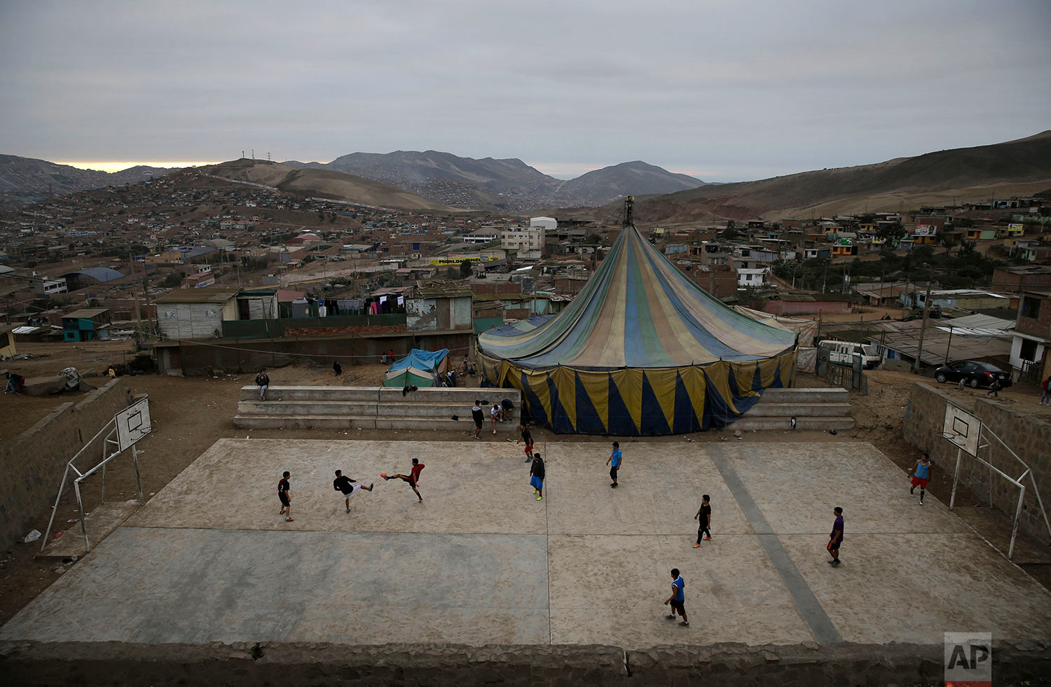  Youths play soccer next to the Tony Perejil circus tent set up in the shantytown of Puente Piedra on the outskirts of Lima, Peru, July 8, 2018. (AP Photo/Martin Mejia) 