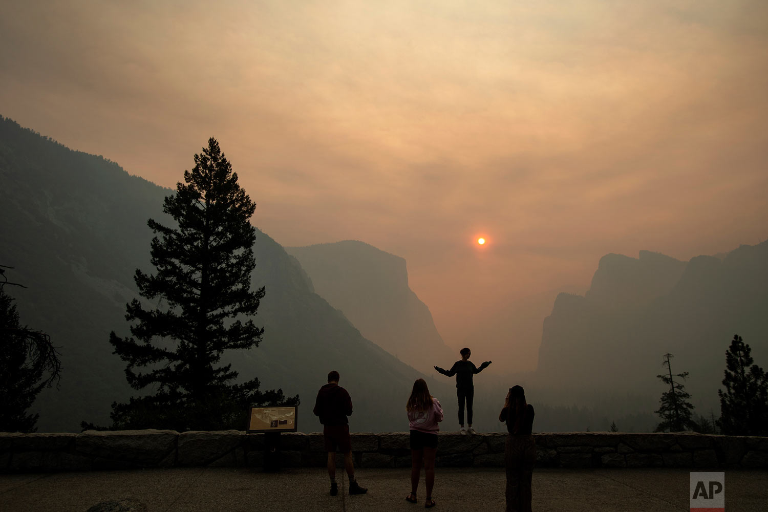  Hannah Whyatt poses for a friend's photo as smoke from the Ferguson fire fills Yosemite Valley, Wednesday, July 25, 2018, in Yosemite National Park, Calif. Campsites and lodges emptied out after disappointed tourists were ordered to leave the heart 