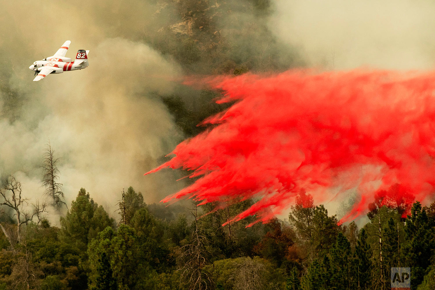  An air tanker drops retardant while fighting to stop the Ferguson Fire from reaching homes in the Darrah community of unincorporated Mariposa Count, Calif., Wednesday, July 25, 2018. (AP Photo/Noah Berger) 