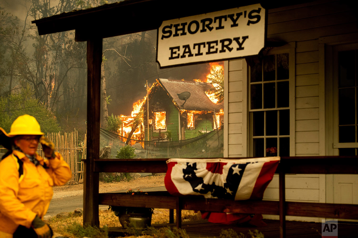  California State Parks Superintendent Lori Martin keeps watch on historic buildings as the Carr Fire burns a residence in Shasta, Calif., Thursday, July 26, 2018. (AP Photo/Noah Berger) 