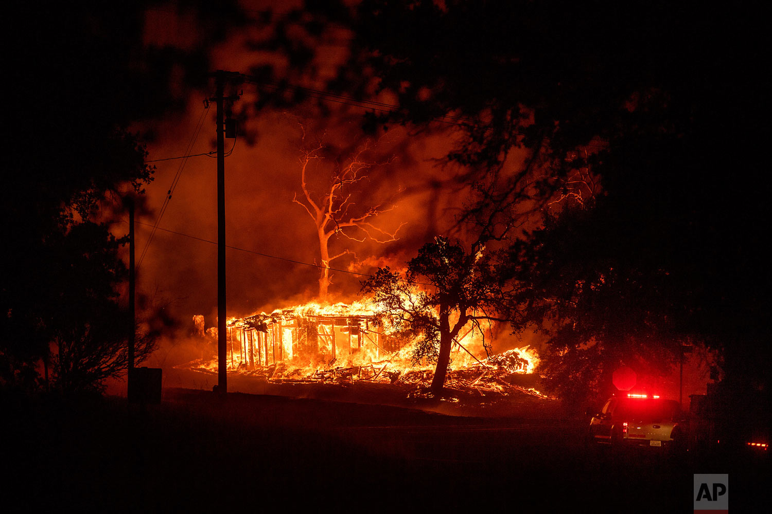  A structure burns as the Carr Fire races along Highway 299 near Redding, Calif., on Thursday, July 26, 2018. (AP Photo/Noah Berger) 