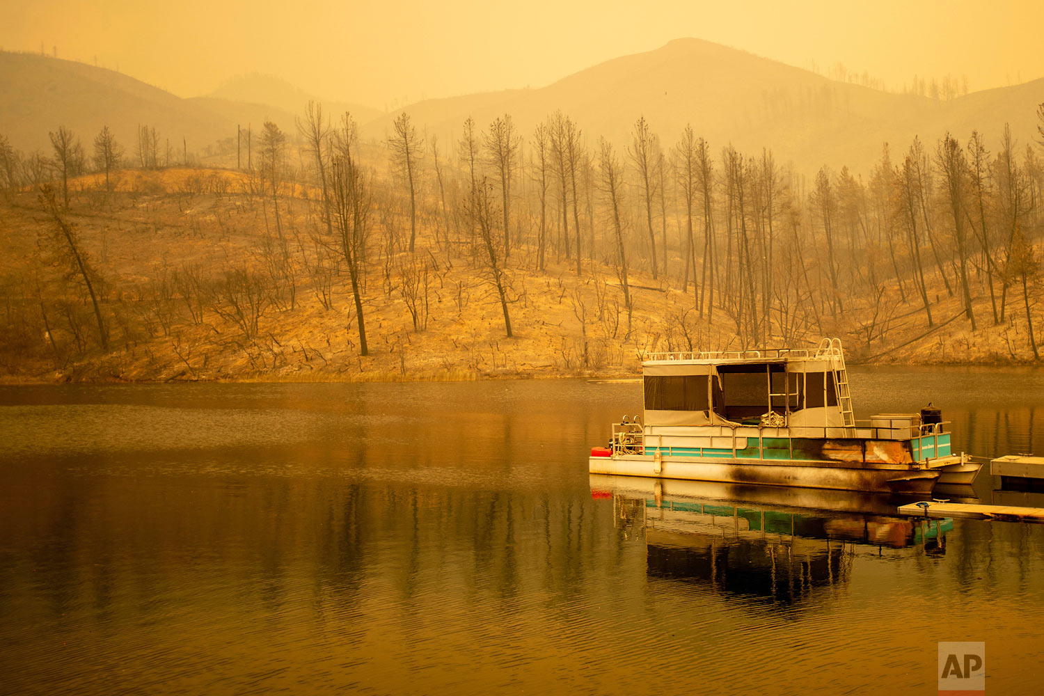  A boat scorched by the Carr Fire floats on Whiskeytown Lake in Whiskeytown, Calif., on Friday, July 27, 2018. The flames moved so fast that firefighters working in oven-like temperatures and bone-dry conditions had to drop efforts to battle the blaz