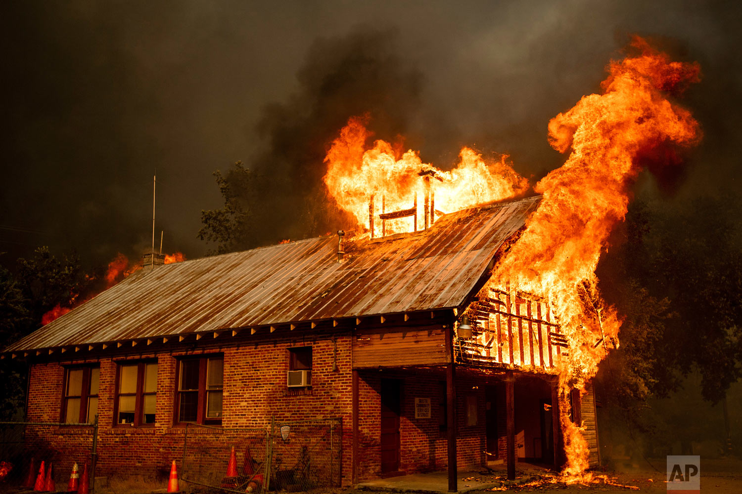 An historic schoolhouse burns as the Carr Fire tears through Shasta, Calif., Thursday, July 26, 2018. The wildfires have been fueled by high temperatures, wind and low humidity in the area. (AP Photo/Noah Berger)