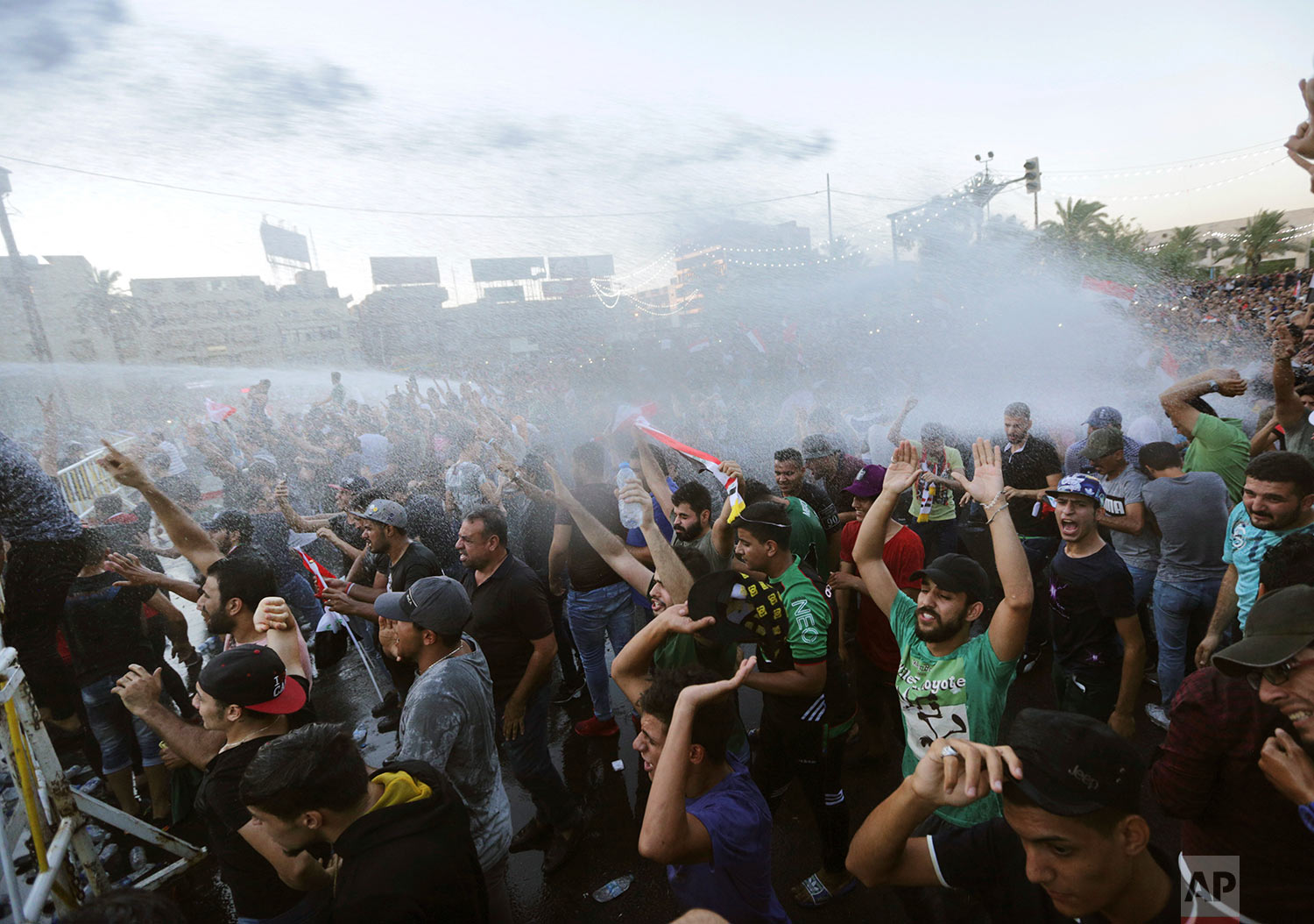  Iraqi security forces hit protesters demanding better public services and jobs with hot water during a demonstration in Tahrir Square in central Baghdad, Iraq, Friday, July 20, 2018. (AP Photo/Hadi Mizban) 