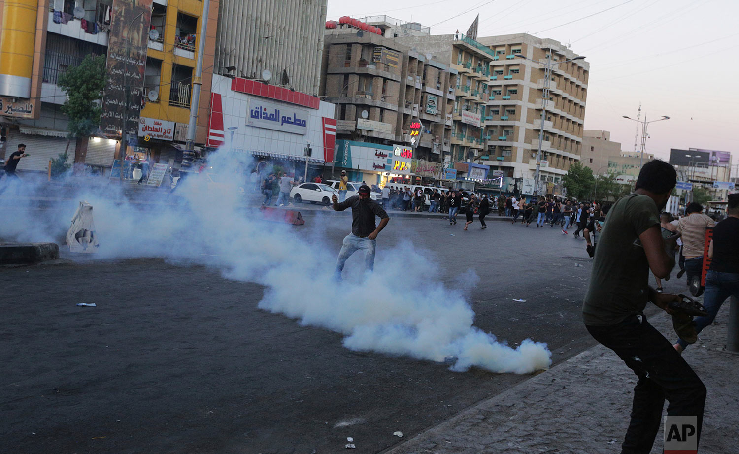  Iraq protesters demanding better public services and jobs run from tear gas fired by security forces, during a demonstration in Tahrir Square in central Baghdad, Iraq, Friday, July 20, 2018. (AP Photo/Hadi Mizban) 