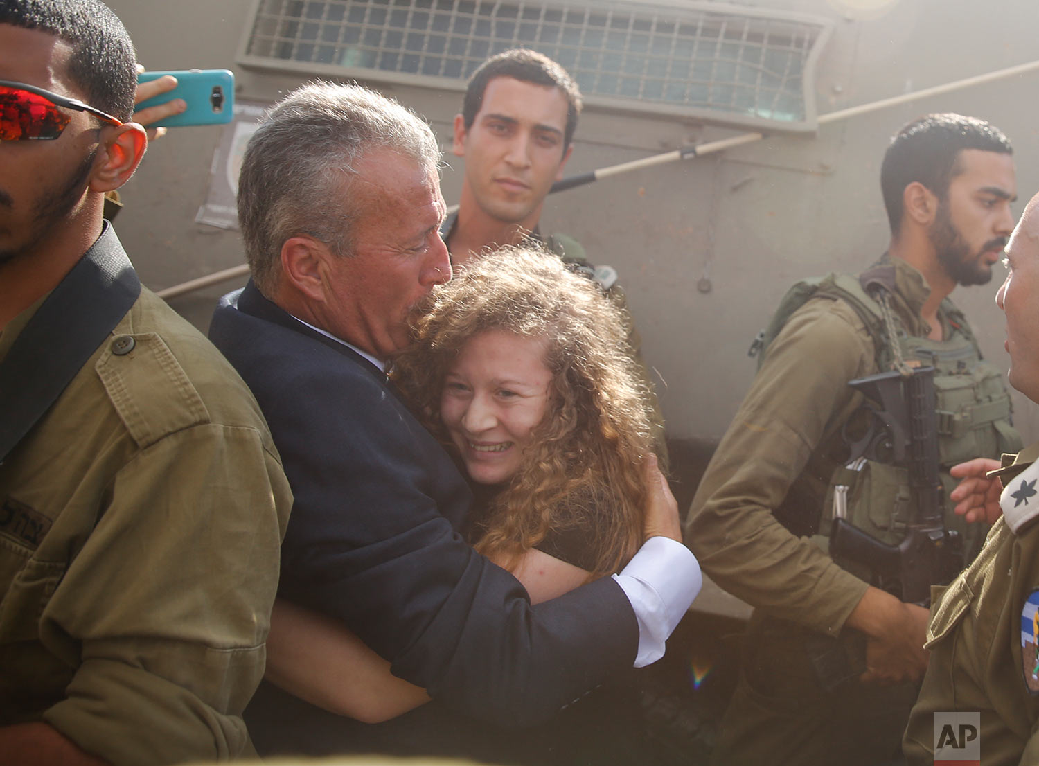  Ahed Tamimi is hugged by her father Bassem as she is released by the Israeli army Israeli prison after serving an eight month sentence at the entrance of her village of Nebi Saleh in the West Bank Sunday, July 29, 2018. (AP Photo/Nasser Shiyoukhi) 