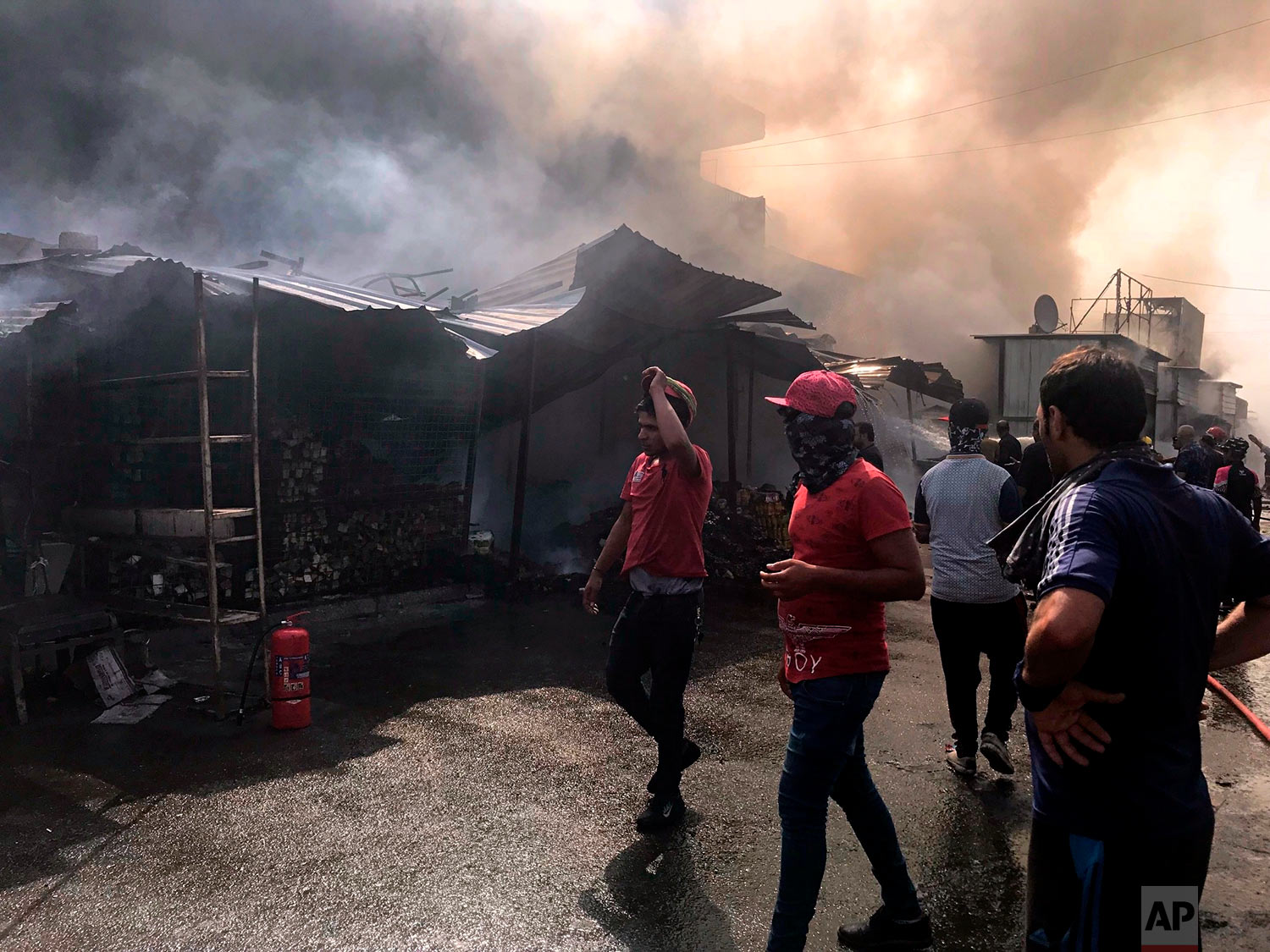  Firefighters work at the scene of a fire that broke out following an electrical fault, in Baghdad's eastern district of Jamila, Iraq, Thursday, July 26, 2018. (AP Photo/Ali Abdul Hassan) 