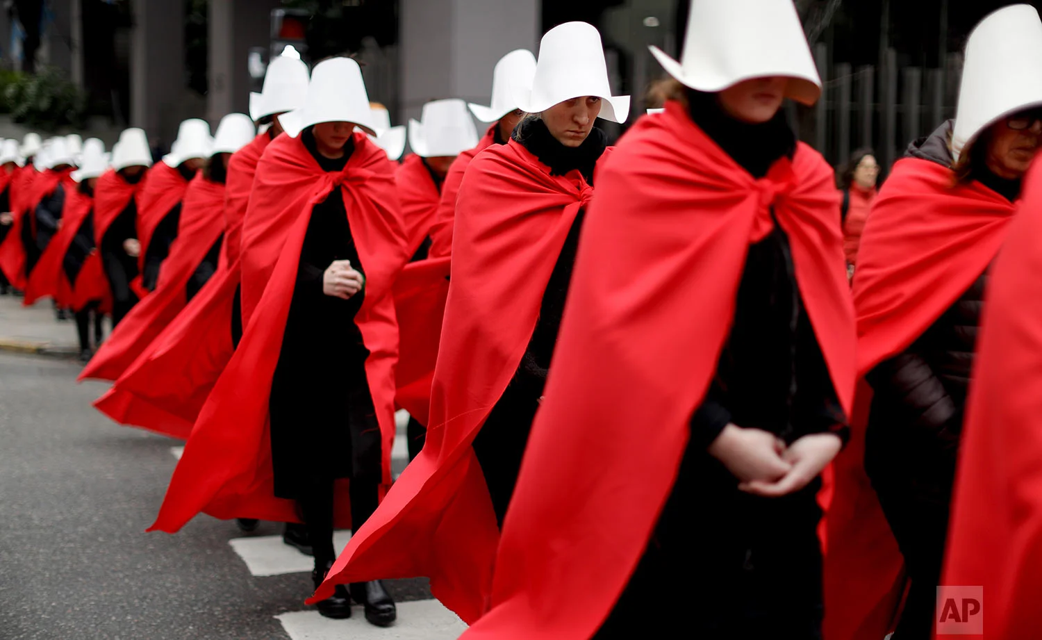 Women in favor of a measure to expand legal abortions wear red cloaks and white bonnets like the characters from the novel-turned-TV series "The Handmaid's Tale" as they march in silence to Congress in Buenos Aires, Argentina, July 25, 2018. Once they reached Congress, one of them read a letter by "Handmaid's Tale" author Margaret Atwood, who supports the effort led by Argentine feminist groups. (AP Photo/Natacha Pisarenko)