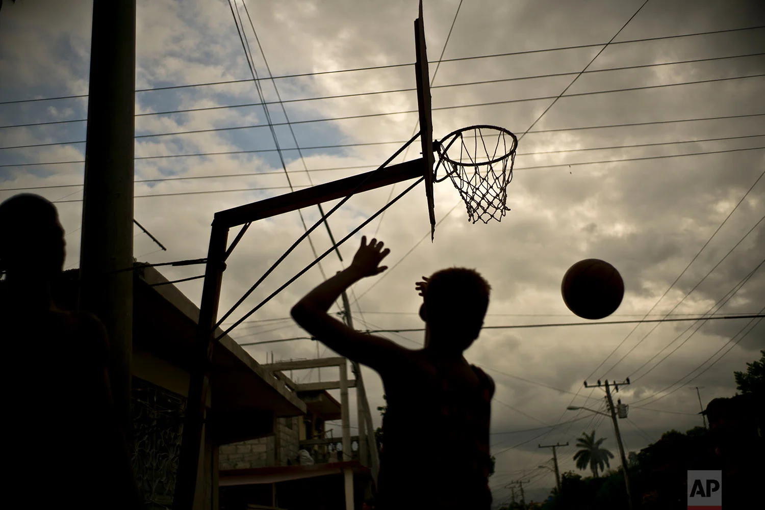 A youth plays basketball in Guantanamo, Cuba, July 24, 2018. Boys on summer break from school often meet at parks for a game of hoops.