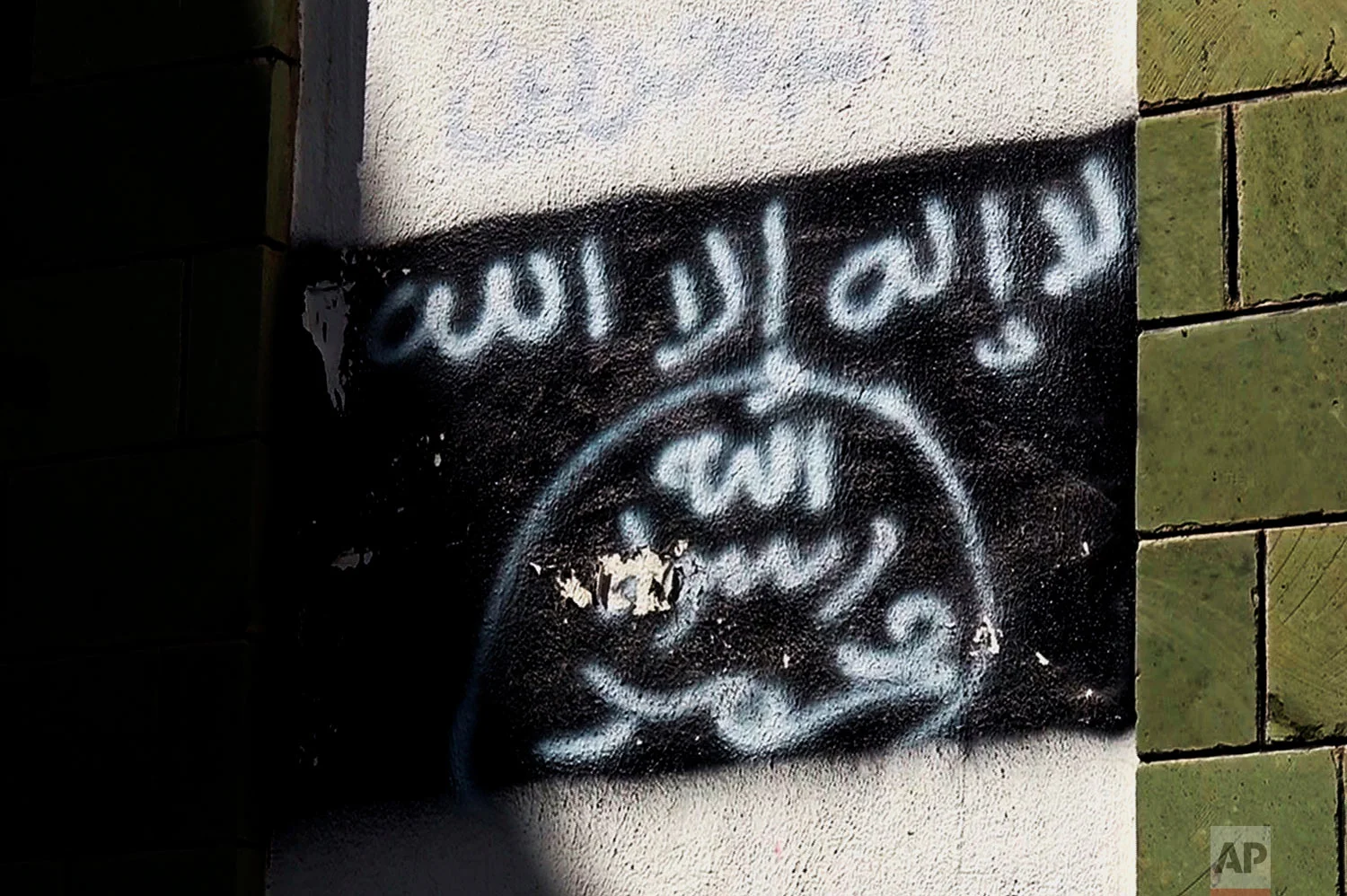 The black al-Qaida flag is sprayed on the wall of a damaged school in Taiz. (AP Photo)