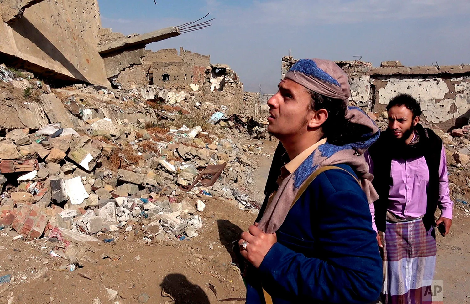 A former al-Qaida commander, Harith al-Ezzi, walks through streets destroyed in fighting in the southern Yemeni city of Taiz. (AP Photo)