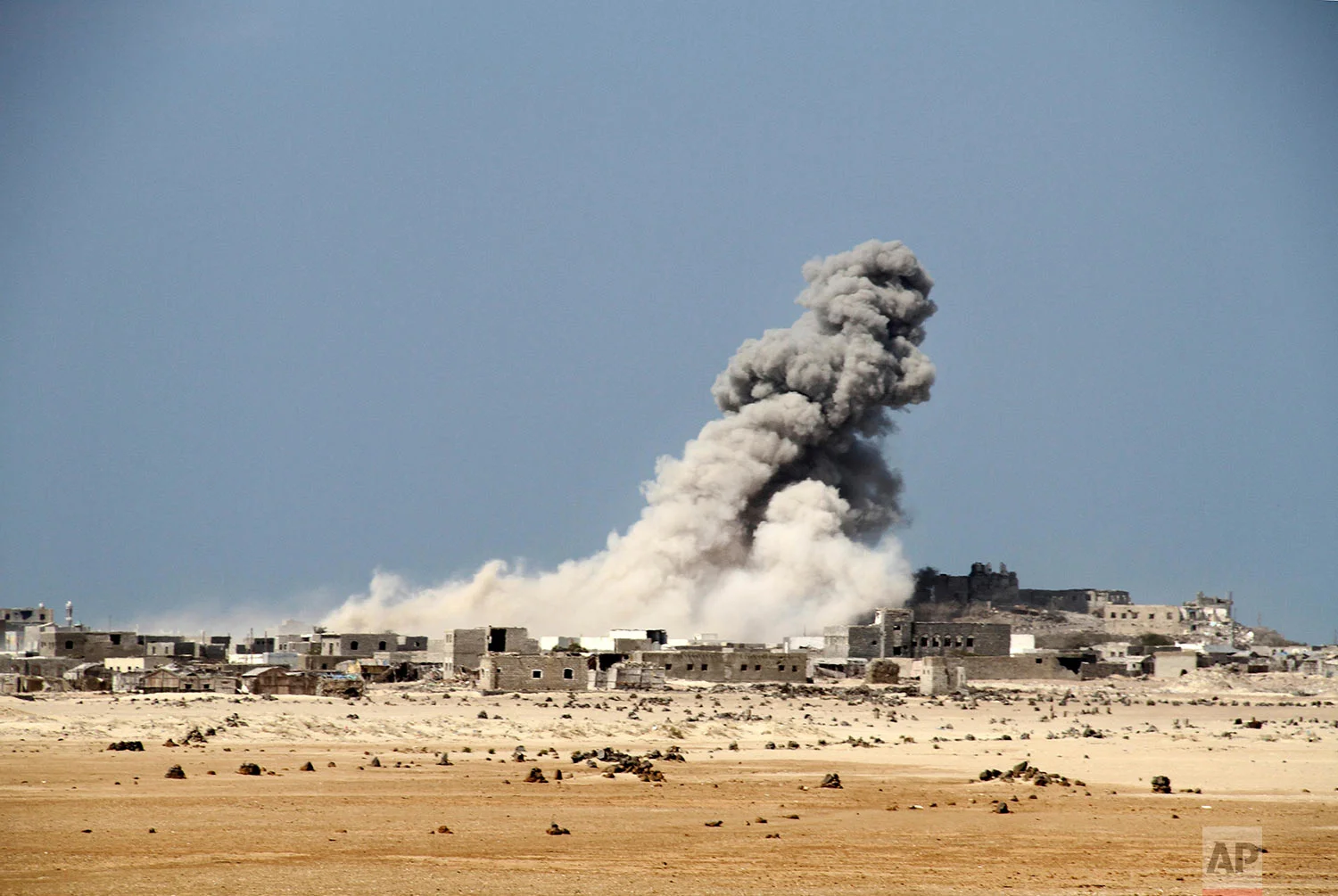 An explosion raises a cloud as coalition-backed fighters advance on the Red Sea port town of Mocha. (AP Photo)
