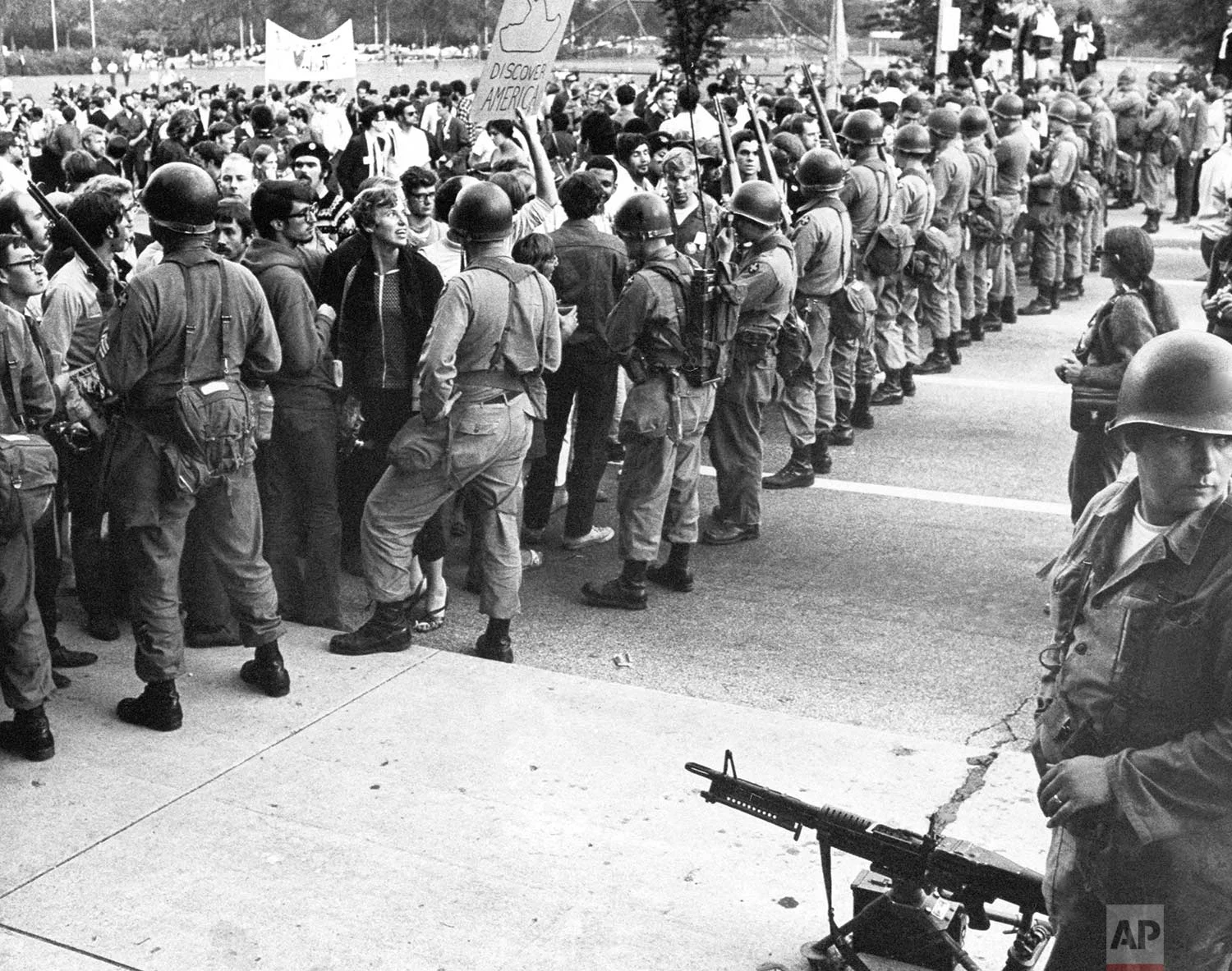 A National Guardsman stands beside a machine gun as others form a barrier against demonstrators in Chicago’s Grant Park on August 28, 1968. (AP Photo)