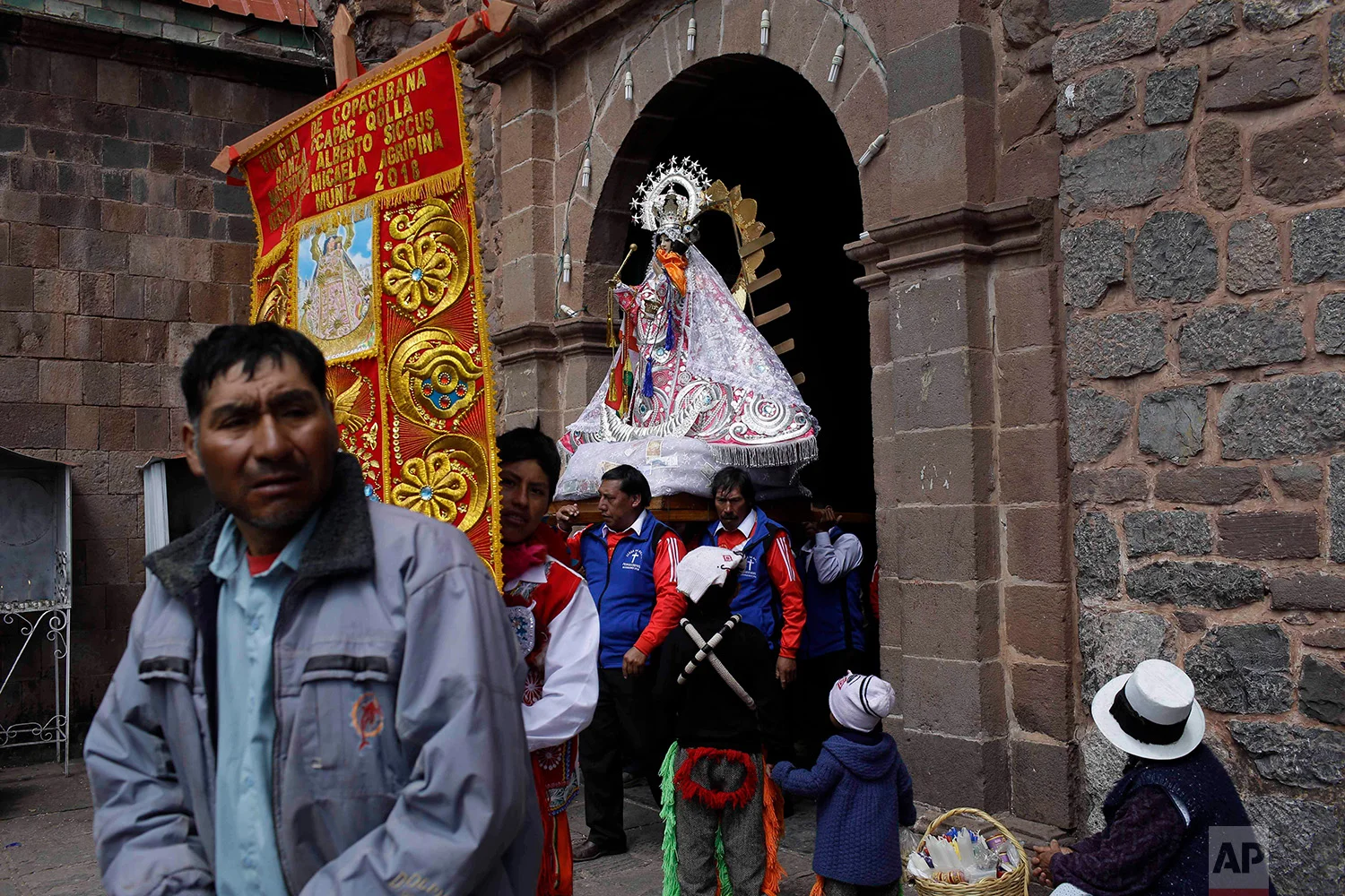  "Cargadores" or male carriers exit the Almudena Temple shouldering a statue of Our Lady of Copacabana, where a service was held in the virgin’s honor, in Cuzco, Peru, Aug. 5, 2018. (AP Photo/Martin Mejia) 