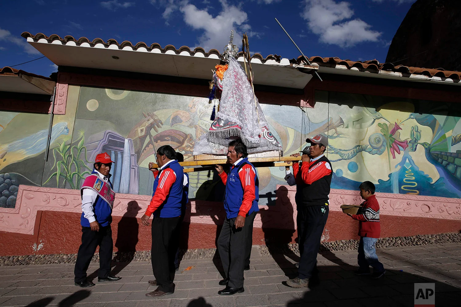  “Cargadores” or male carriers walk with a statue of Our Lady of Copacabana belonging to resident Libia Espinoza, in a religious procession honoring the Bolivian virgin, in Cuzco, Peru, Aug. 5, 2018. (AP Photo/Martin Mejia) 
