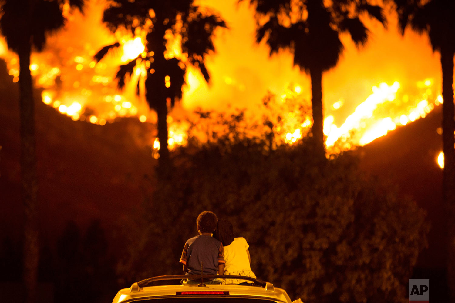  Princess Bass, 5, rests her head on the shoulder of her brother, King, 6, as they sit and watch the Holy Fire burn from on top of their parents' car Thursday night, Aug. 9, 2018 in Lake Elsinore, Calif. More than a thousand firefighters battled to k