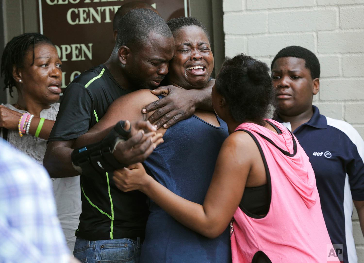  The mother, center, of two young children is comforted after she found them stabbed to death in their father's apartment in Houston on Saturday, Aug. 4, 2018. Authorities say that Jean Pierre Ndossoka, the man suspected of fatally stabbing his two c