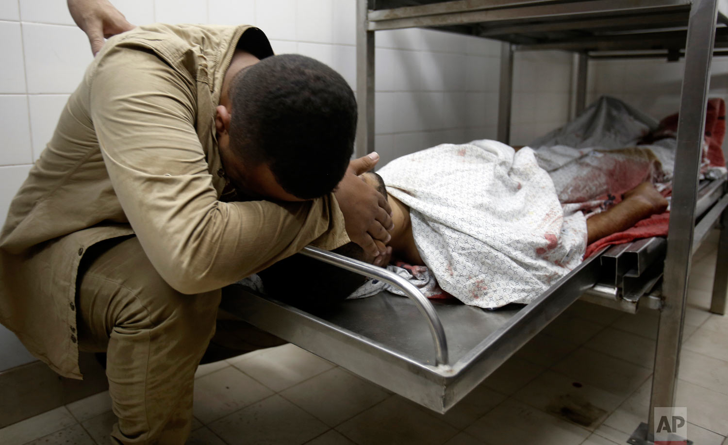  A relative mourns over the body of Abdullah al-Qutati, 26, at the morgue of the European hospital east of Khan Younis, southern Gaza Strip, east of Khan Younis, Friday, Aug. 10, 2018. Two Palestinians, including a paramedic, were shot and killed by 