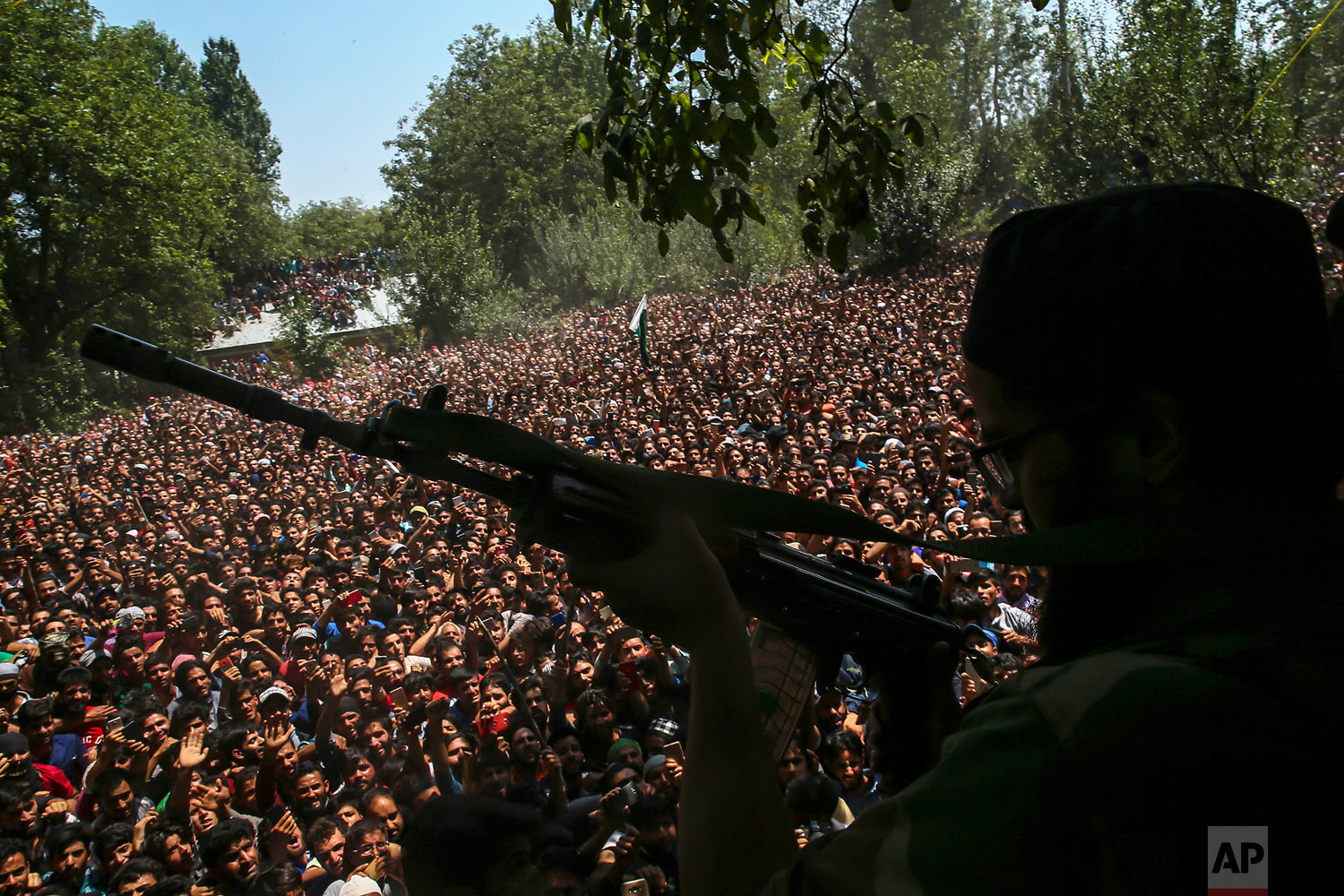  A Kashmiri rebel fires his gun to salute fallen comrades during their joint funeral in Malikgund village, south of Srinagar, Indian controlled Kashmir, Saturday, Aug. 4, 2018. At rebels and an Indian army soldier were killed in gunbattles in dispute