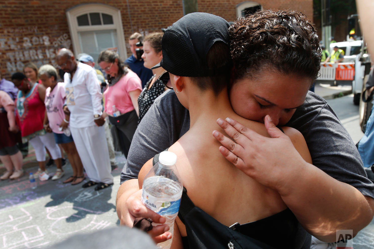  A couple embrace as they participate in prayers at the intersection where Heather Heyer was killed last year as they mark the anniversary of the Unite the Right rally in Charlottesville, Va., Sunday, Aug. 12, 2018. On that day, white supremacists an