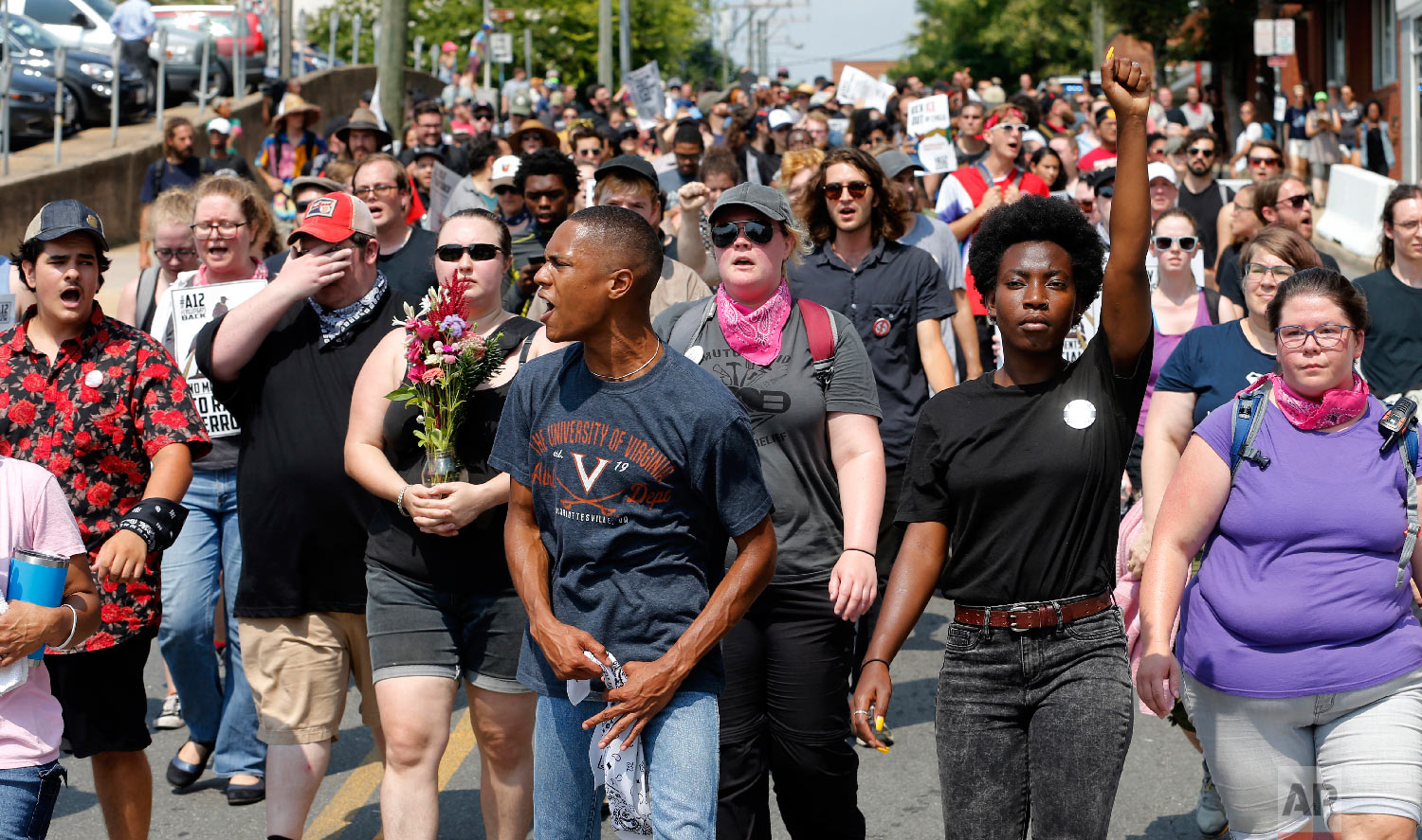  Demonstrators against racism march along city streets as they mark the anniversary of last year's Unite the Right rally in Charlottesville, Va., Sunday, Aug. 12, 2018. (AP Photo/Steve Helber) 