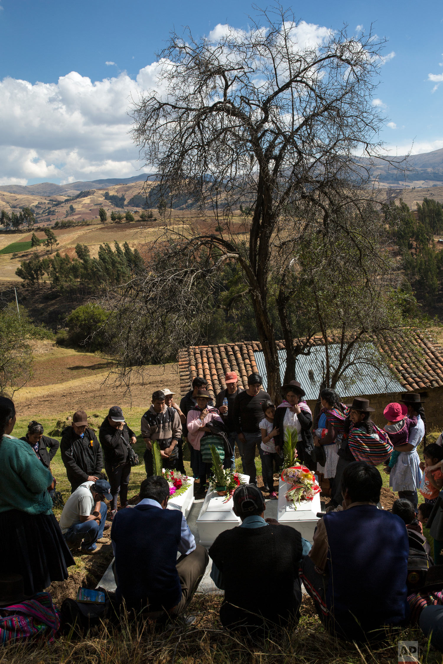  In this Aug. 15, 2018 photo, villagers gather around the coffins of their loved ones who were killed by Shining Path guerrillas in 1984, during their proper burial at the cemetery in Tantana, in Peru's Ayacucho province. (AP Photo/Rodrigo Abd) 