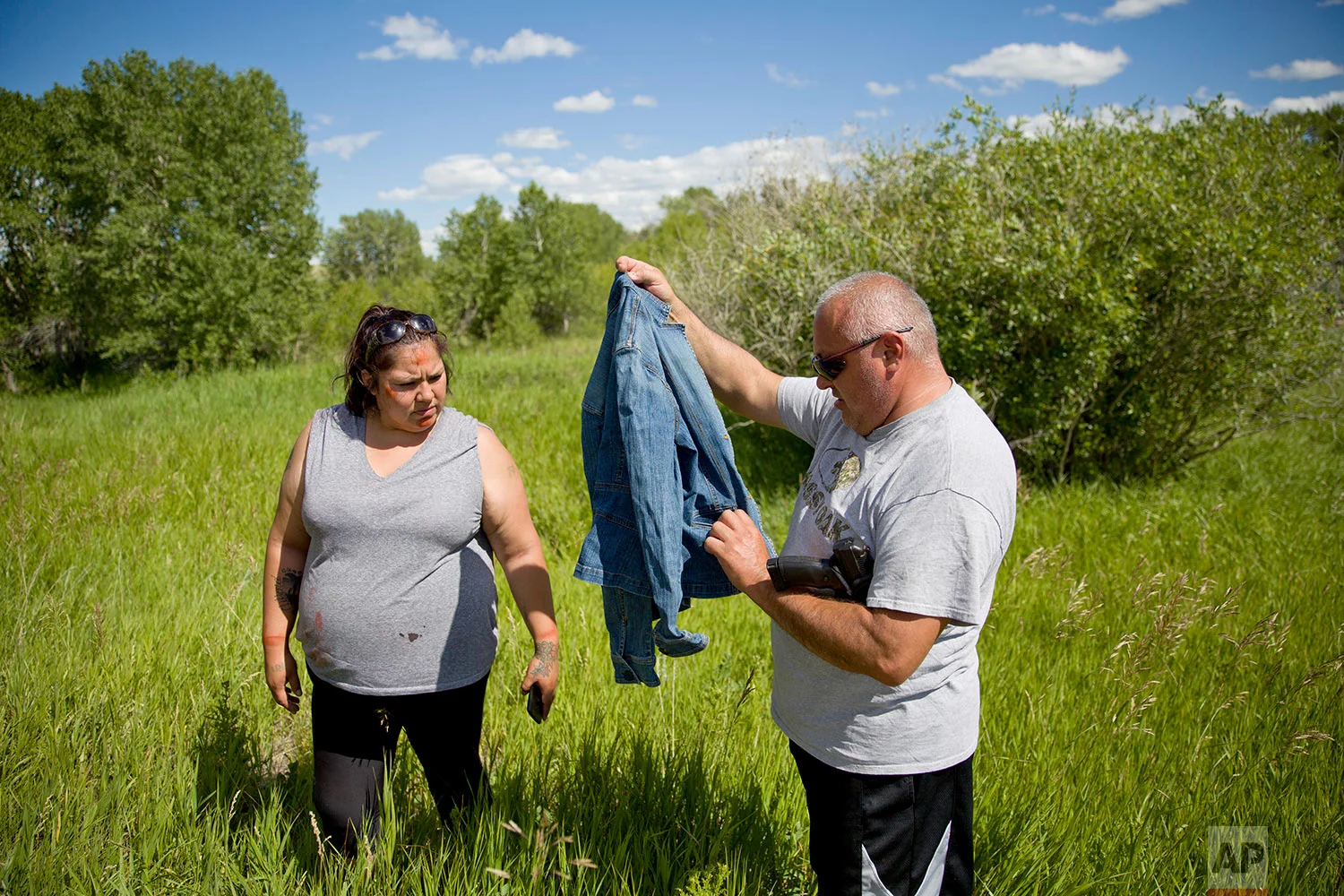 George A. Hall, right, holds up a jacket found with Lissa Loring, during a search in Valier. Mont., for Loring's cousin, Ashley HeavyRunner Loring, July 11, 2018. (AP Photo/David Goldman)