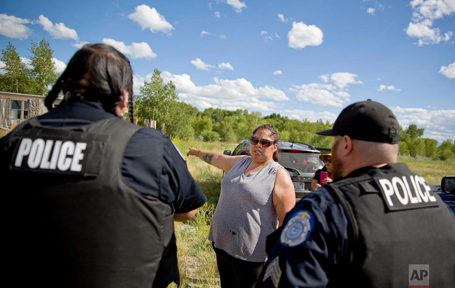 Lissa Loring points Blackfeet law enforcement officers to a trailer in Valier, Mont., where she believes clues have been found during a search for her cousin, Ashley HeavyRunner Loring, July 11, 2018. (AP Photo/David Goldman)