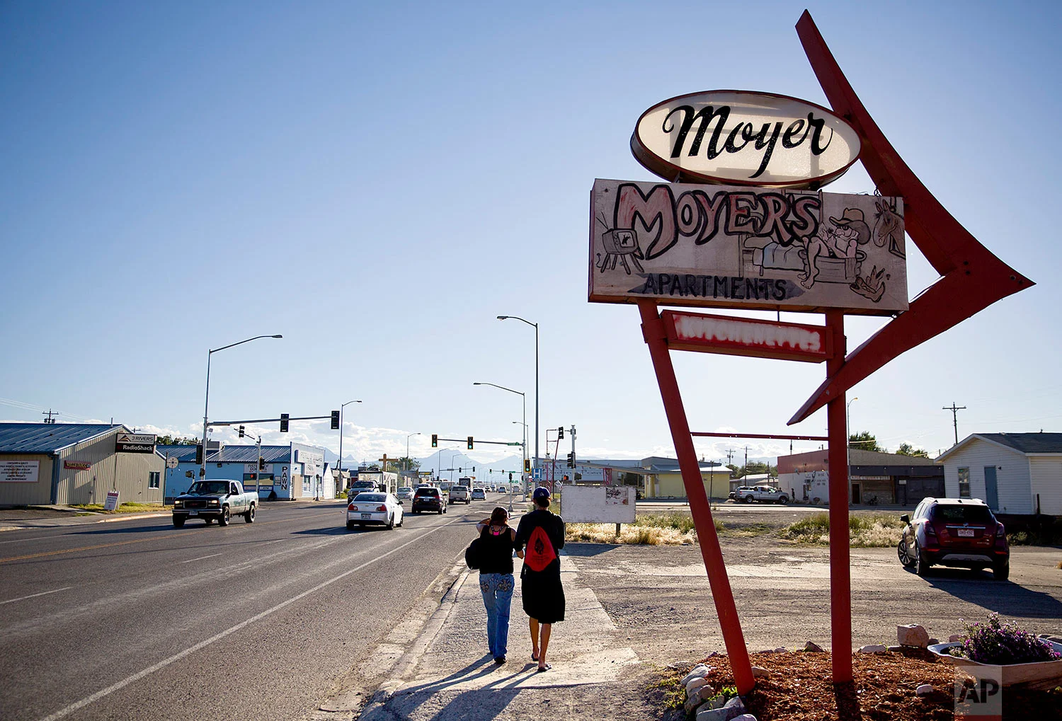 A couple walks through the main business district on the Blackfeet Indian Reservation in Browning, Mont., July 11, 2018. (AP Photo/David Goldman)