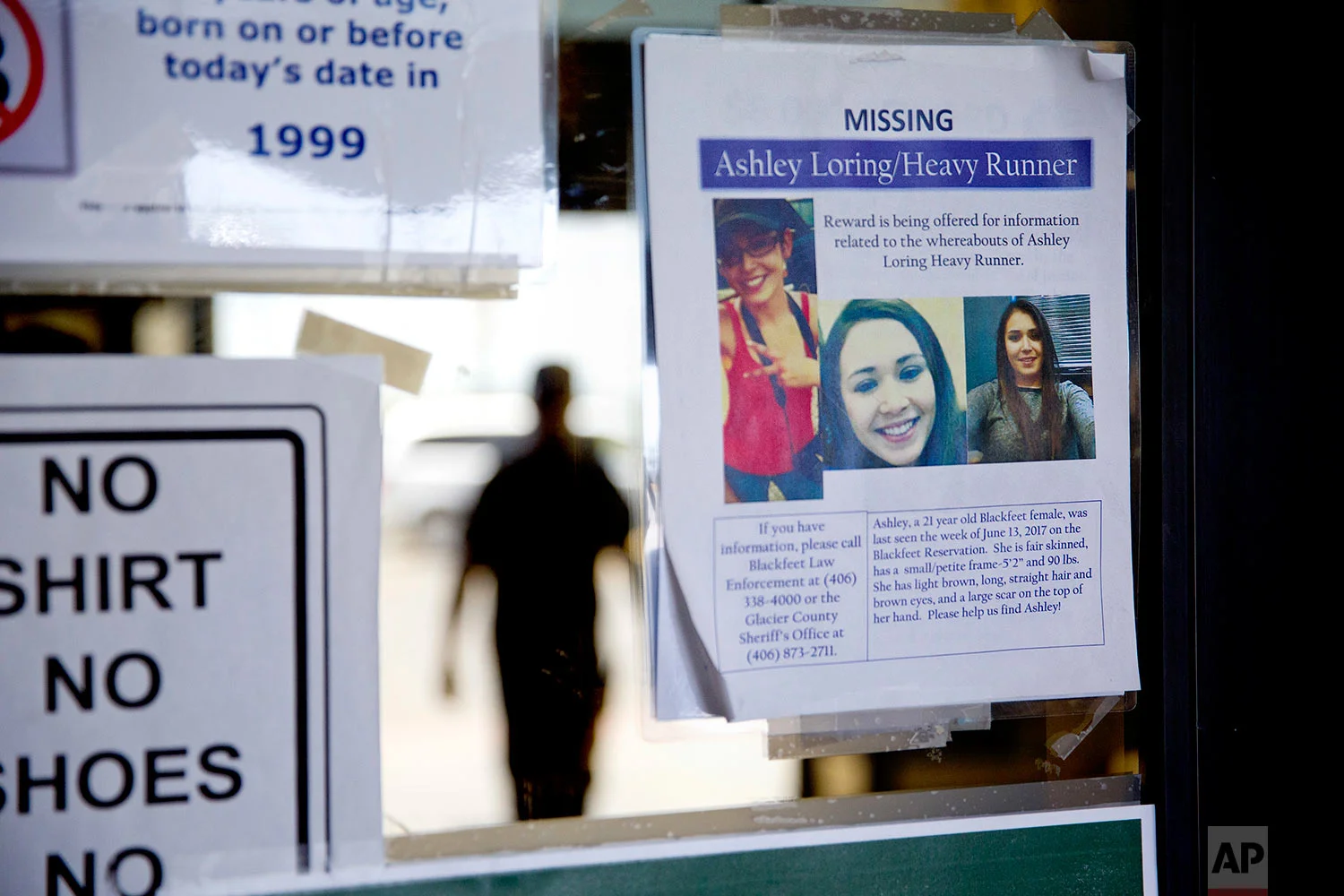 A missing poster for Ashley HeavyRunner Loring is posted to the entrance of a grocery store on the Blackfeet Indian Reservation in Browning, Mont., July 12, 2018. (AP Photo/David Goldman)